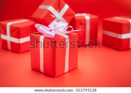 Red gift box with  ribbon on red background. 