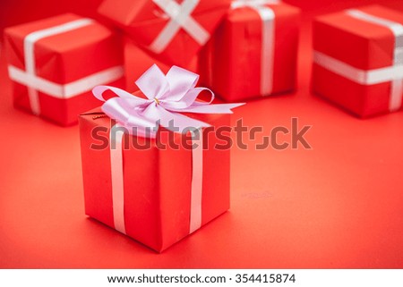 Red gift box with  ribbon on red background. 