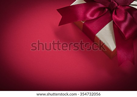 Wrapped giftbox on red background holidays concept.