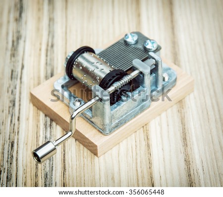 Old little music box on the wooden background. Retro style. Musical instrument.