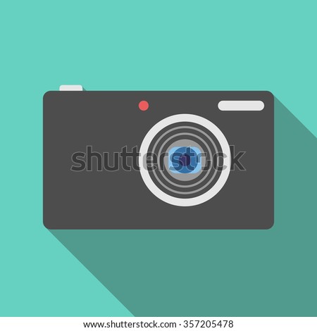 Compact digital photo camera on turquoise blue background with long drop shadow. Flat style
