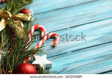 Christmas tree branch with baubles on blue wooden table