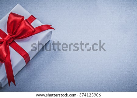 Gift red bow on blue background greeting card holidays concept.