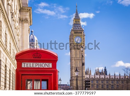Traditional red british telephone box and Big Ben at Parliament Square with blue sky and clouds - London, UK