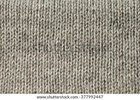 detail of the handmade knitted pattern (light gray) of wool and alpaca winter yarn