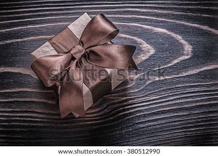Wrapped gift box on wooden board holidays concept.