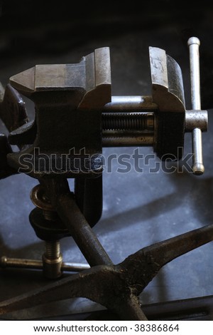 Old vice grip on dark background with metal construction