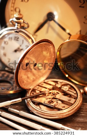 Hour workshop. Vintage still life with ancient silver pocket watch and tools