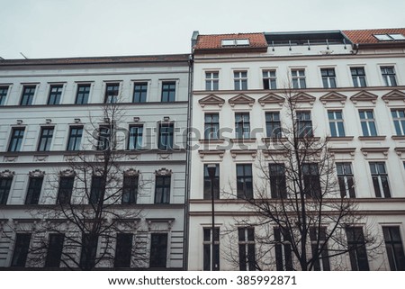 Low Angle Architectural Exterior View of Classical Low Rise Buildings in Urban City Setting with Bare Trees on Overcast Day with Gray Sky