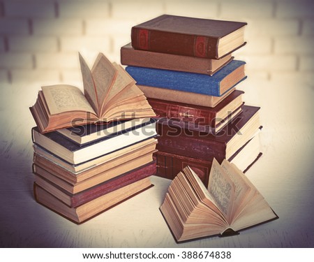Heap of old books on brick wall background
