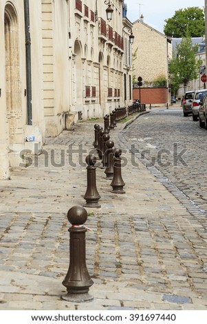 It's an old paved streets and sidewalks separated from each other by metal bars in one of the small French towns.