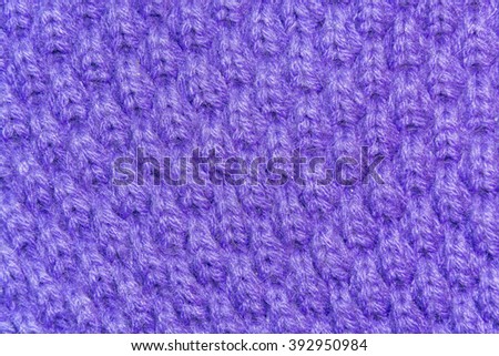 texture of a knitted purple woolen fabric closeup