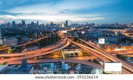 Aerial view highway intersection with city downtown background during twilight