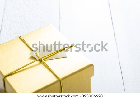 golden gift box on white wood table background