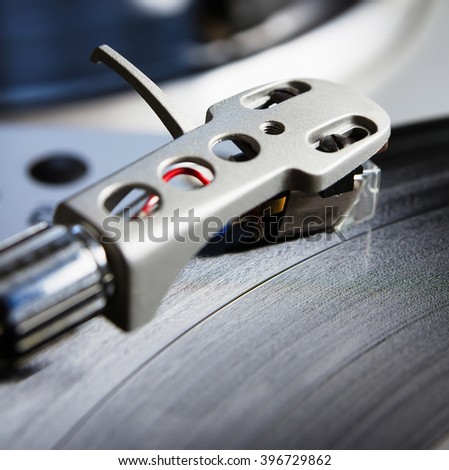 Turntable player with musical vinyl record. Useful for DJ, nightclub and retro theme. Focus on the time code and needle head shell
