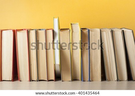 Stack of colorful books on wooden table. Education background. Back to school. Copy space for text.
