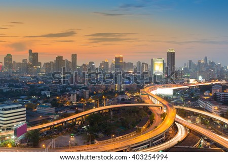 Beauty of sunset sky over city downtown background and road interchange, long exposure 