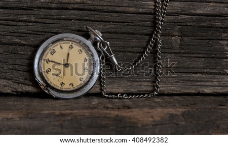 Old pocket watch on a textured vintage background