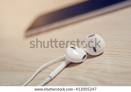 close up modern headphone with blurred smartphone background