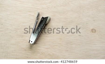 Stainless steel stapler on wooden surface. Isolated on empty background. Slightly de-focused and close-up shot. Copy space.
