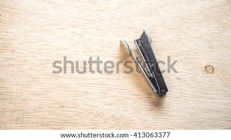 Retro styled or retro color stainless steel stapler on a wooden surface. Isolated on empty background. Slightly de-focused and close-up shot. Copy space.