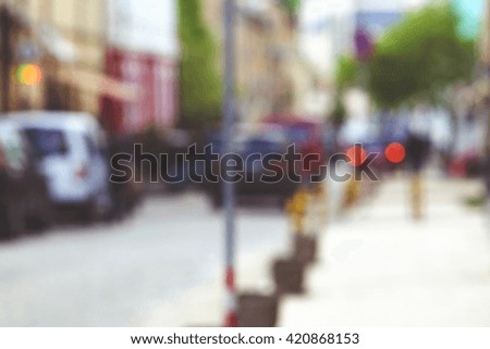 Blurred city street in European city in bokeh. Defocused background. Toned photo.
