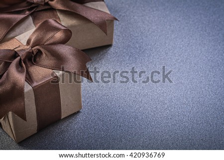 Set of gift boxes in brown wrapping paper on grey background celebrations concept.