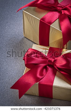 Giftboxes in glittery paper on grey background vertical view holidays concept.