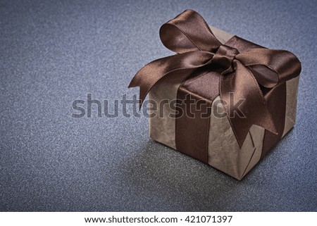 Giftbox with brown tape on grey background celebrations concept.