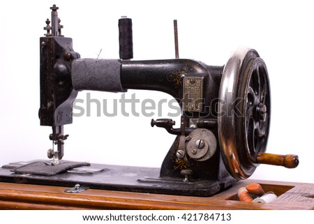 Old black manual sewing machine for sewing on a white background