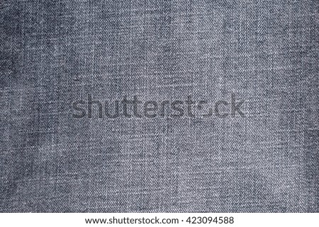 the textured background from rough cotton material or denim of pale color