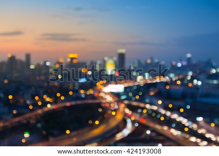 Abstract blurred bokeh lights, city downtown background and highway after sunset