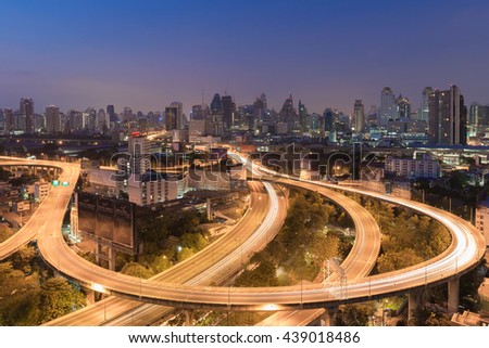Highway road curved long exposure with city downtown background before sunrise