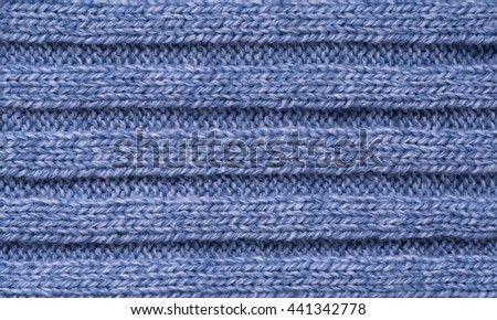 The texture of a knitted woolen cloth is blue, with a ribbed pattern stripes. background