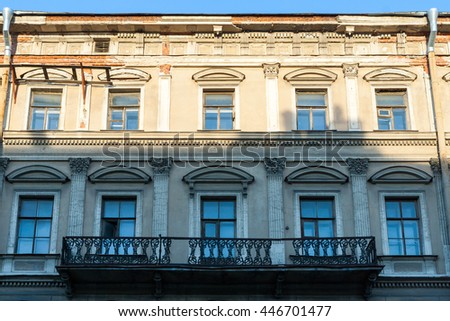 Facade of classic house with windows and a balcony. 