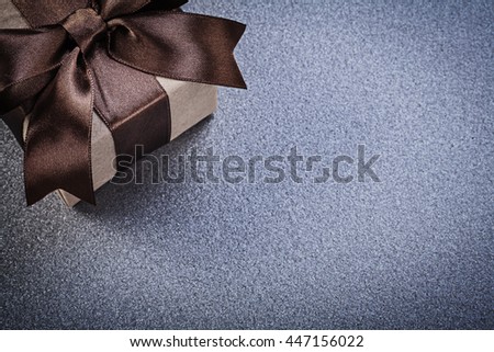 Present box in wrapping paper on grey background celebrations concept.