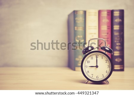 Clock showing nine o clock on table with blurred background