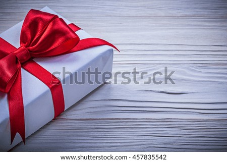 Gift box with red ribbon directly above holidays concept.
