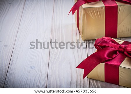 Birthday gift boxes with red bows on wooden board holidays concept.