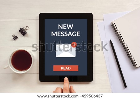 New message concept on tablet screen with office objects on white wooden table. All screen content is designed by me.