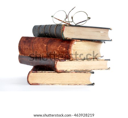 Vintage spectacles above stack of old books on white background