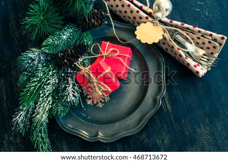Christmas time table setting with vintage silverware on plate and napkin. Toned image