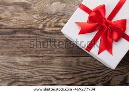White box with a red bow on the old board