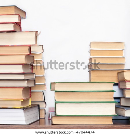 pile of old books on a wooden table on light background