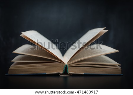 Open book on a background of black school board