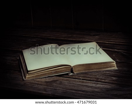 old antique opened book with blank pages on a wooden table. Color toned.