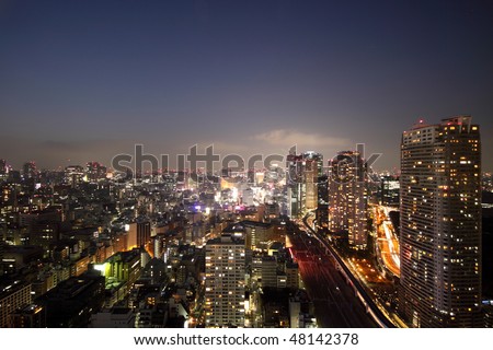 Illuminated buildings and roads of night skyline in Tokyo during sunset
