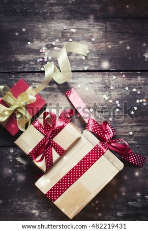 Christmas presents with red ribbon on dark wooden background in vintage style
