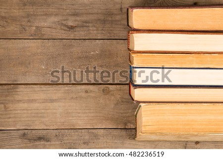 Old and used hardback books or text books on wooden table