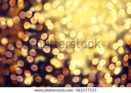 		Dark Gold Festive blur background. Abstract night twinkled bright background with bokeh defocused golden lights. Christmas blurry boke lights
